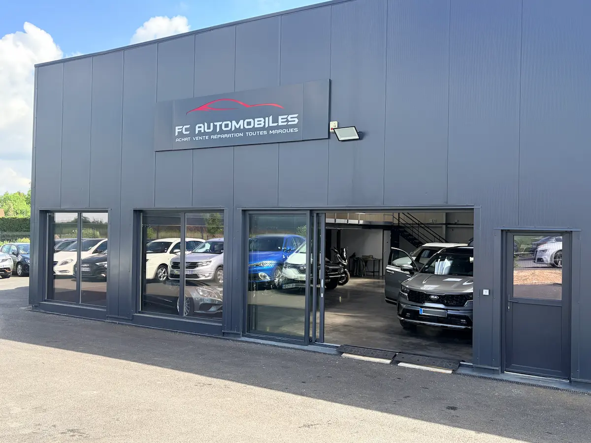 Façade du garage FC Automobiles à Moyvillers — bâtiment ZAC du Poirier, enseigne « FC Automobiles · achat vente réparation toutes marques »